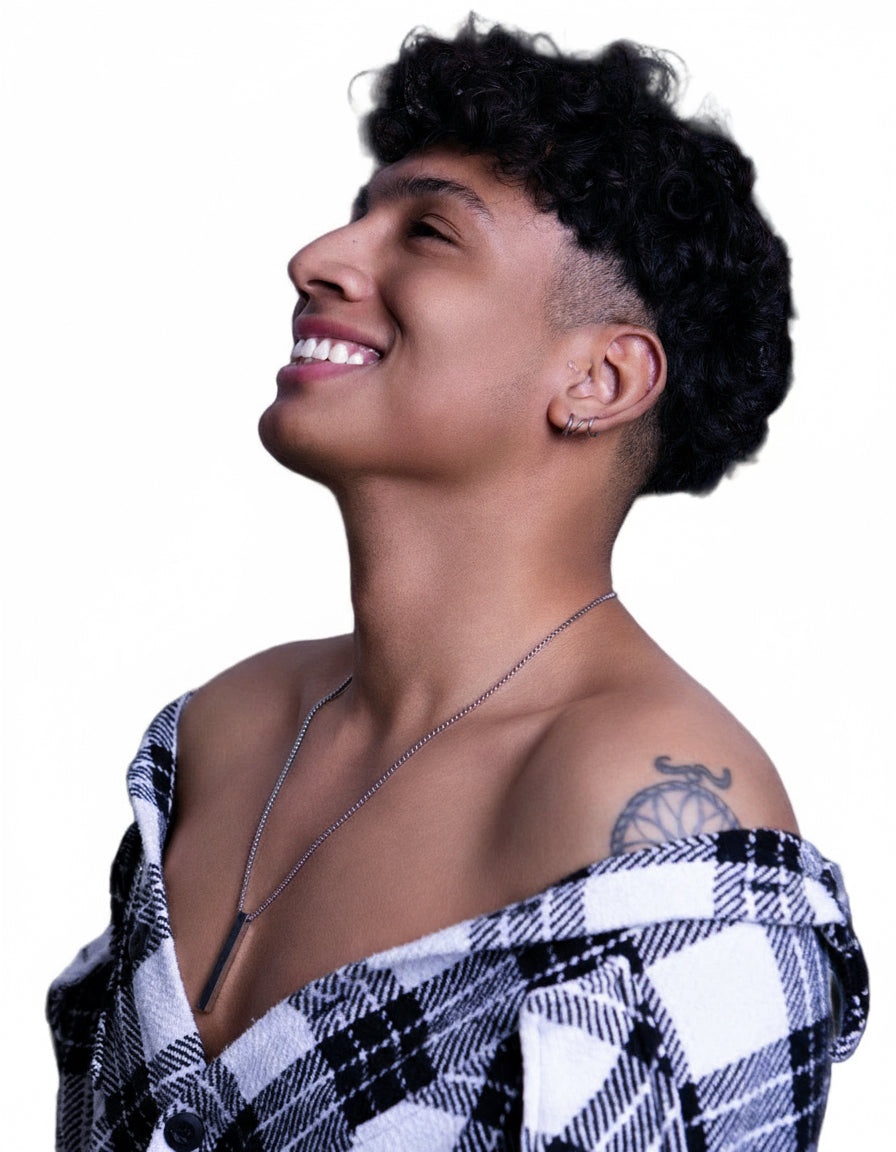 Person wearing a black and white checkered top with a tattoo on shoulder against a white background